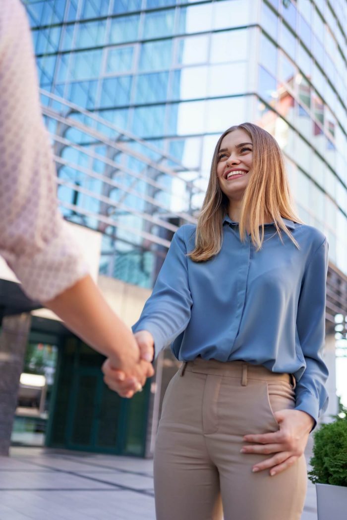 woman-hands-shake-on-business-building-background-1.jpg